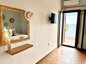 a room with a mirror and a view of the ocean at Magic estate on the wave 2 by Villa Lagkadaki in Kotronas