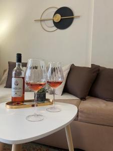 two wine glasses on a table with a bottle of wine at Castle Town Apartment in Dhidhimótikhon +6 photos