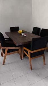a wooden table with two chairs and a table with bananas on it at Casa completa en Puente Moreno Ver in Playa de Vacas +3 photos