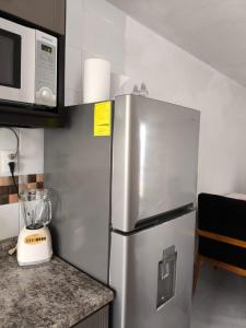 a stainless steel refrigerator in a kitchen with a microwave at Casa completa en Puente Moreno Ver in Playa de Vacas