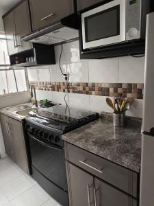 a kitchen with a stove and a microwave at Casa completa en Puente Moreno Ver in Playa de Vacas