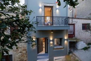 an external view of a house with a balcony at Evmaria Luxury Cottage in Agios Myronas