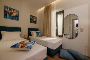 a hotel room with two beds and a mirror at Evmaria Luxury Cottage in Agios Myronas
