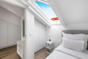 a bedroom with a bed and a skylight at Mirante in Mokošica