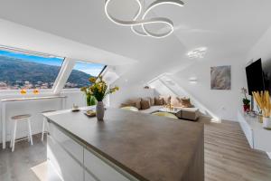 a kitchen and living room with white walls and windows at Mirante in Mokošica