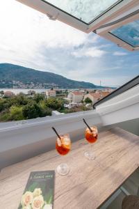 two wine glasses sitting on a table in front of a window at Mirante in Mokošica