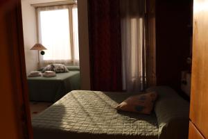 a small bedroom with two beds and a window at Monika Holiday 315 Magic Lake in Garda