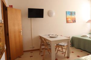a room with a table and a television on a wall at Monika Holiday 315 Magic Lake in Garda