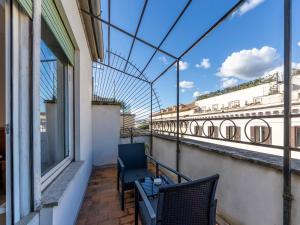 a balcony with two chairs and a glass roof at Hotel Diplomatic in Rome