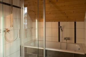 a bathroom with a shower and a bath tub at st martin chalets in Sankt Michael im Lungau +133 photos
