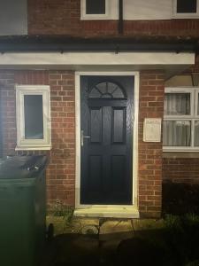 a black door on the side of a brick house at Godwinning lodge in Thamesmead