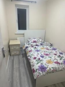 a bedroom with a bed with a floral comforter at Godwinning lodge in Thamesmead