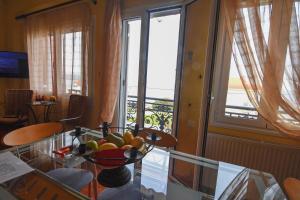 a room with a glass table with a bowl of fruit at Evaggelia's Seaside Boutique Apartment in Ireon +19 photos