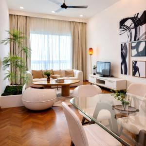 a living room with a couch and a table and chairs at Straits Quay Seafront Suite l Panoramic Seaview in Tanjong Tokong