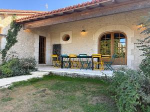 a patio with yellow chairs and a table on a house at Villa Leynie in Festalemps