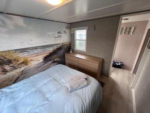 a bedroom with a painting of the beach at Beach House Giethoorn in Wanneperveen