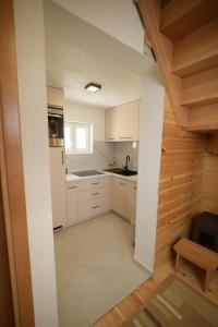 a kitchen with white cabinets and a wooden wall at Planinski vuk chalet in Žabljak