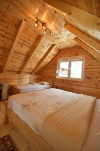a bedroom with three beds in a log cabin at Planinski vuk chalet in Žabljak