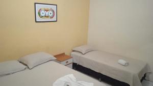 a room with two beds and a picture on the wall at Hotel Netuno Beach in Fortaleza