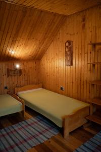 a bedroom with two beds in a wooden room at Privat Luna in ľubeľa