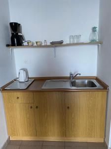 a kitchen counter with a sink and a microwave at Valentina Rooms in Qeparo