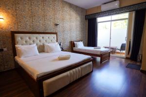 a hotel room with a bed and a chair and a window at CROWN REGENCY- BADULLA in Badulla