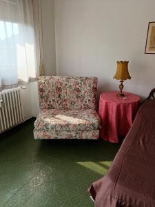 a room with a chair and a table with a lamp at Villa Rosa in Rapallo