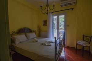 a bedroom with a bed and a door to a balcony at Evaggelia's Seaside Boutique Apartment in Ireon