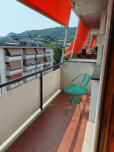a green chair sitting on the balcony of a building at Villa Rosa in Rapallo