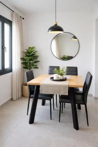a dining room table with black chairs and a mirror at Atlantis Four in Éxo Goniá +12 photos