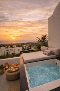 a bath tub on a balcony with a sunset at Atlantis Four in Éxo Goniá