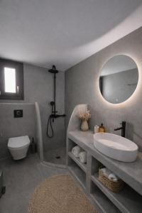a bathroom with a sink and a toilet and a mirror at Atlantis Four in Éxo Goniá