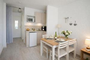 a kitchen and dining room with a table and chairs at centre port le cocon 4 couchages in Cap d'Agde