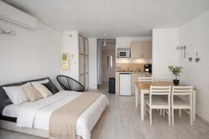 a bedroom with a bed and a table and a kitchen at centre port le cocon 4 couchages in Cap d'Agde