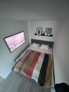 a small bedroom with a bed with a striped blanket at Casa Båstad in Båstad