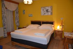 a bed in a room with a yellow wall at Pension Restaurant Rosenberg in Jennersdorf +94 photos