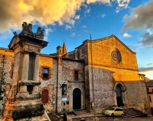 an old church with a car parked in front of it at Arkham Casa Vacanze in Amelia