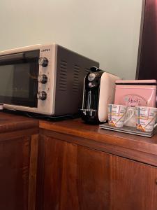 a microwave sitting on top of a wooden counter at Arkham Casa Vacanze in Amelia