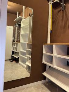 a walk in closet with white shelves and a mirror at Arkham Casa Vacanze in Amelia