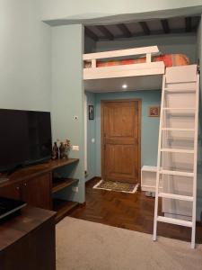 a bedroom with a bunk bed with a television and a ladder at Arkham Casa Vacanze in Amelia