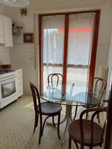 a glass table and chairs in a kitchen with a window at Villa Rosa in Rapallo