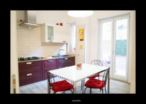 a kitchen with a white table and red chairs at Casa Porta D'Amalfi vicino Stazione e terminal Sita Salerno in Salerno