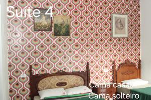 a bedroom with a wall with a red and white wallpaper at Hostel Jai Juquehy in Juquei +57 photos