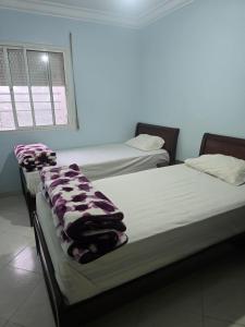 two beds sitting next to each other in a room at Residence Bassatine in Temara