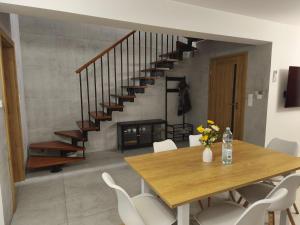 a dining room with a table and a staircase at Lisia Górka in Debina