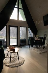 a living room with a table and a dining room at Acasa Straja - Green Cottage in Lupeni