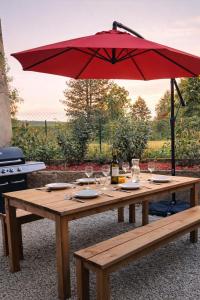 a wooden picnic table with a red umbrella at Maison 8p 4ch A31 Recharge electrique in Rolampont