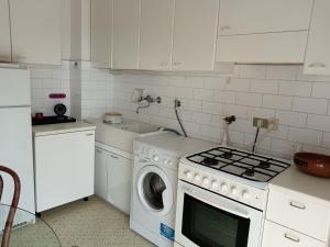 a kitchen with a stove and a washing machine at Villa Rosa in Rapallo