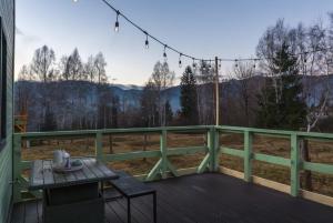 a balcony with a table and a view of the mountains at Acasa Straja - Green Cottage in Lupeni