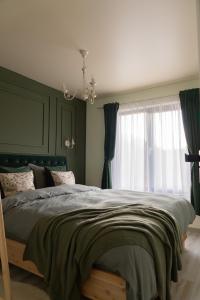 a bedroom with a large bed and a window at Acasa Straja - Green Cottage in Lupeni
